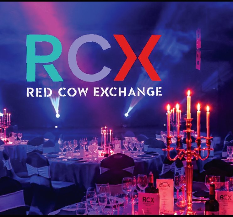 Banquet tables with candelabra under blue lighting at RCX